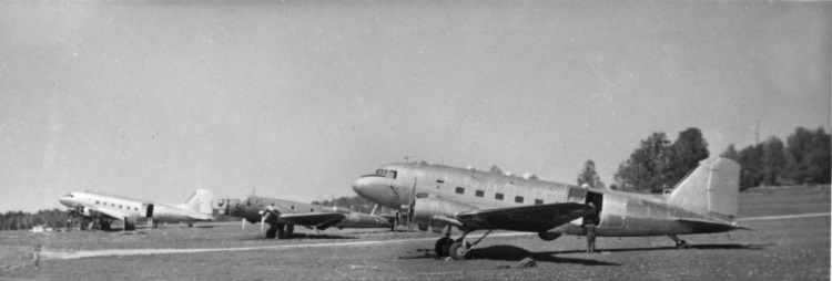 Tre flygplan, varav två är DC-3:or den i förgrunden är den som sköts ned.