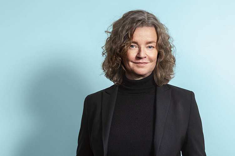 Leende kvinna i svart kavaj.